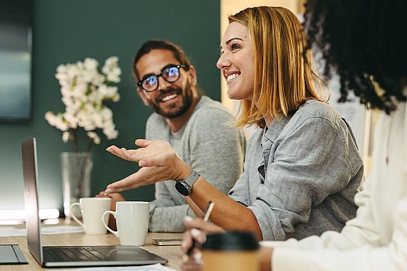 Zwei Personen arbeiten gemeinsam am Laptop, symbolisiert Team- & Projektarbeit bei hpm (Hofmann Projektmanagement)