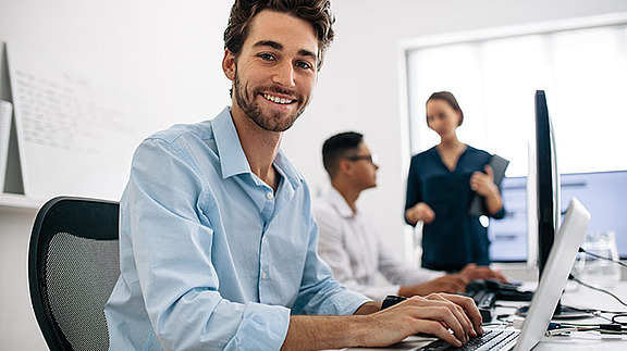 Berufseinstieg im Callcenter – Mitarbeiter bearbeitet Kundenanfragen am Bildschirm