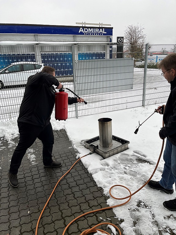 Mitarbeiter von Hofmann Personal löscht bei einer Brandschutzhelferschulung ein kleines Feuer.