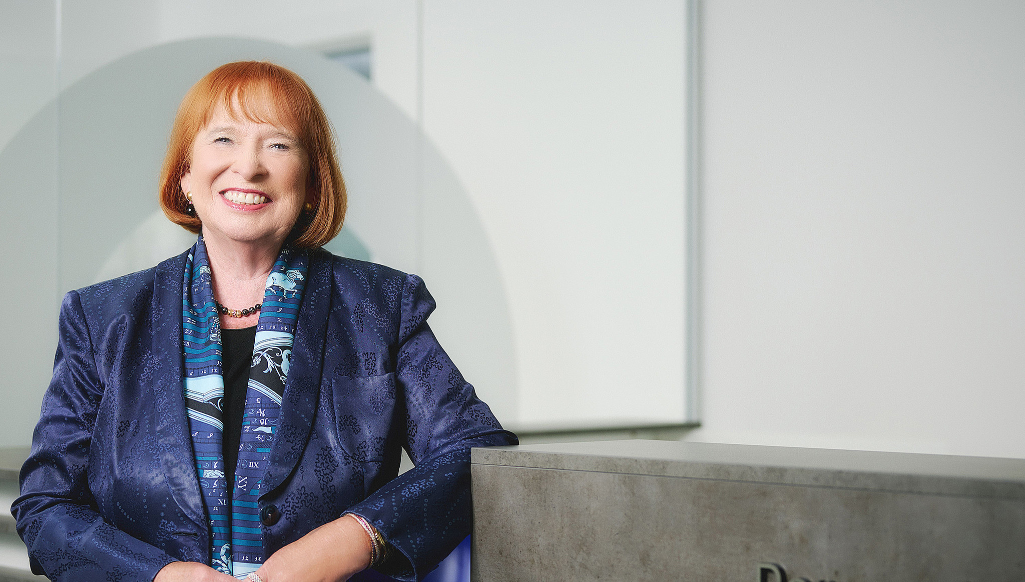 Geschäftsführerin der I. K. Hofmann GmbH, Fr. Hofmann angelehnt an Tresen im modernen Büro