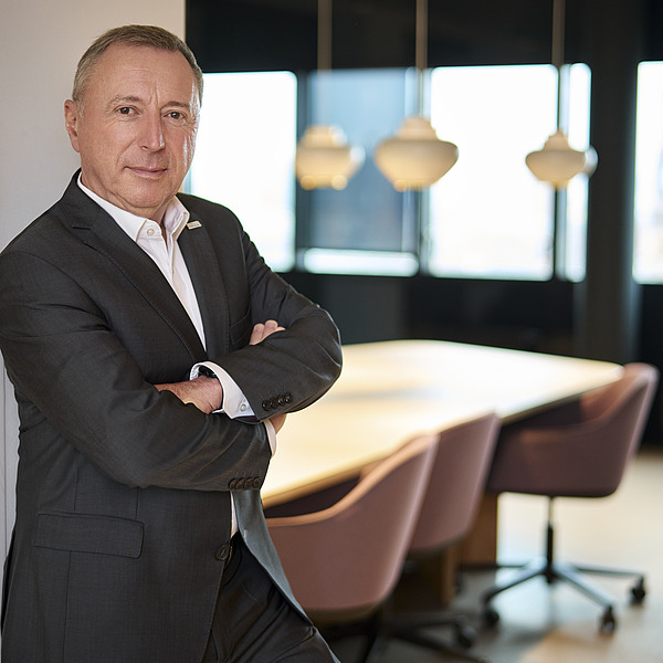 Mitglied des Executive Committee in Businesskleidung vor einem modernen Konferenzraum