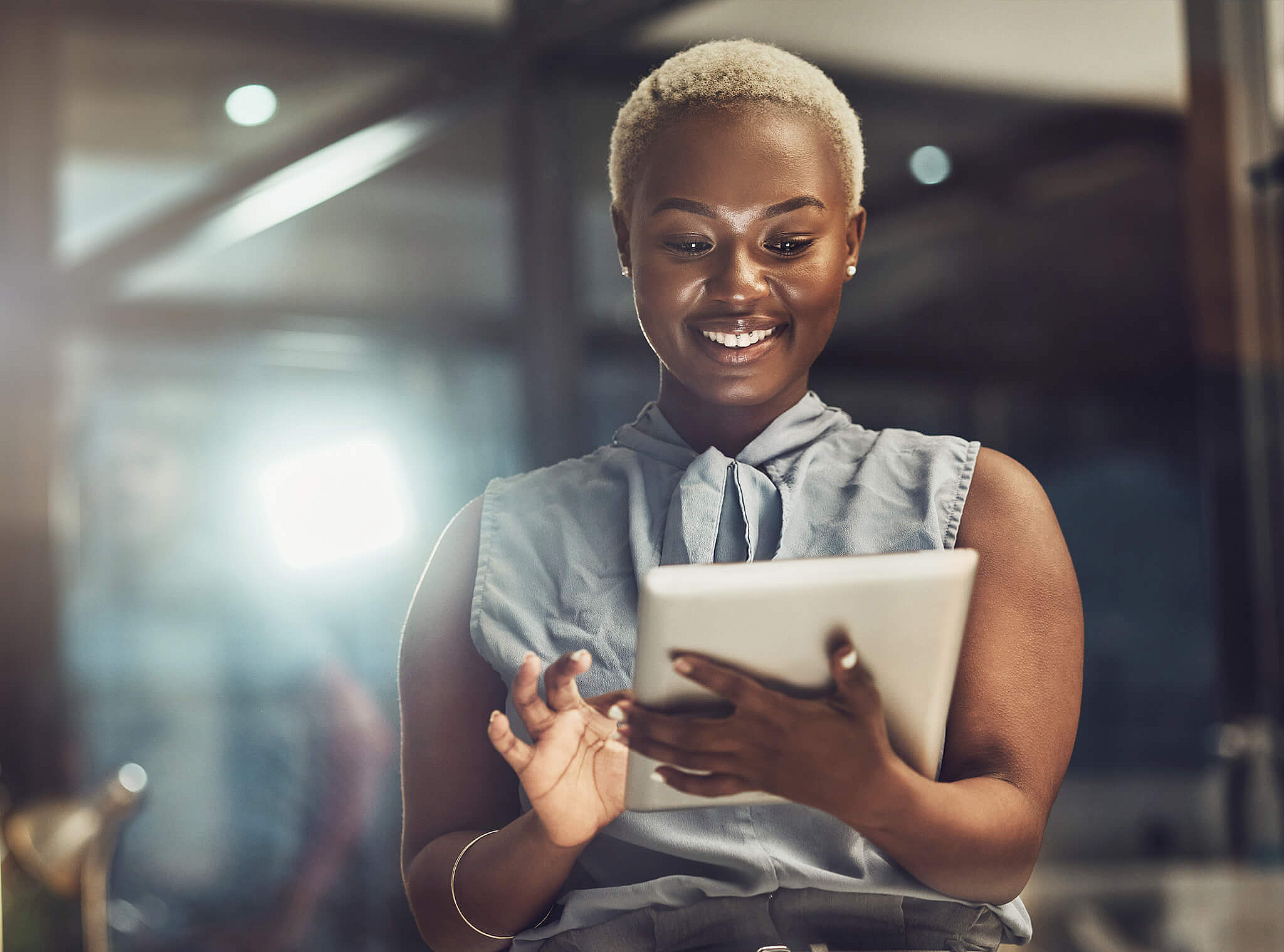 Frau nutzt Tablet in moderner Arbeitsumgebung, symbolisiert digitale Arbeitsprozesse bei medcareer