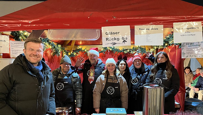 Gruppenfoto mit Oberbürgermeister Marcus König am Stand von Hofmann Personal beim Weihnachtsmarkt Langwasser.