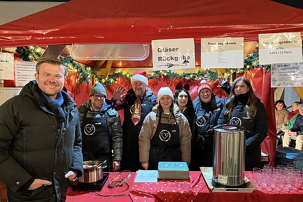 Gruppenfoto mit Oberbürgermeister Marcus König am Stand von Hofmann Personal beim Weihnachtsmarkt Langwasser.