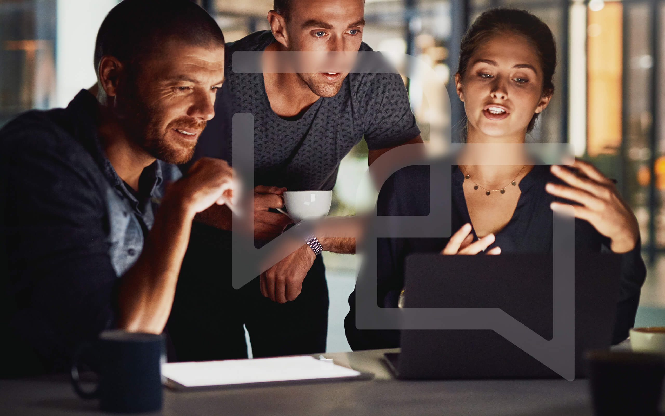 Drei Mitarbeiter bei hpm (Hofmann Projektmanagement) im Gespräch am Arbeitsplatz in moderner Büroumgebung