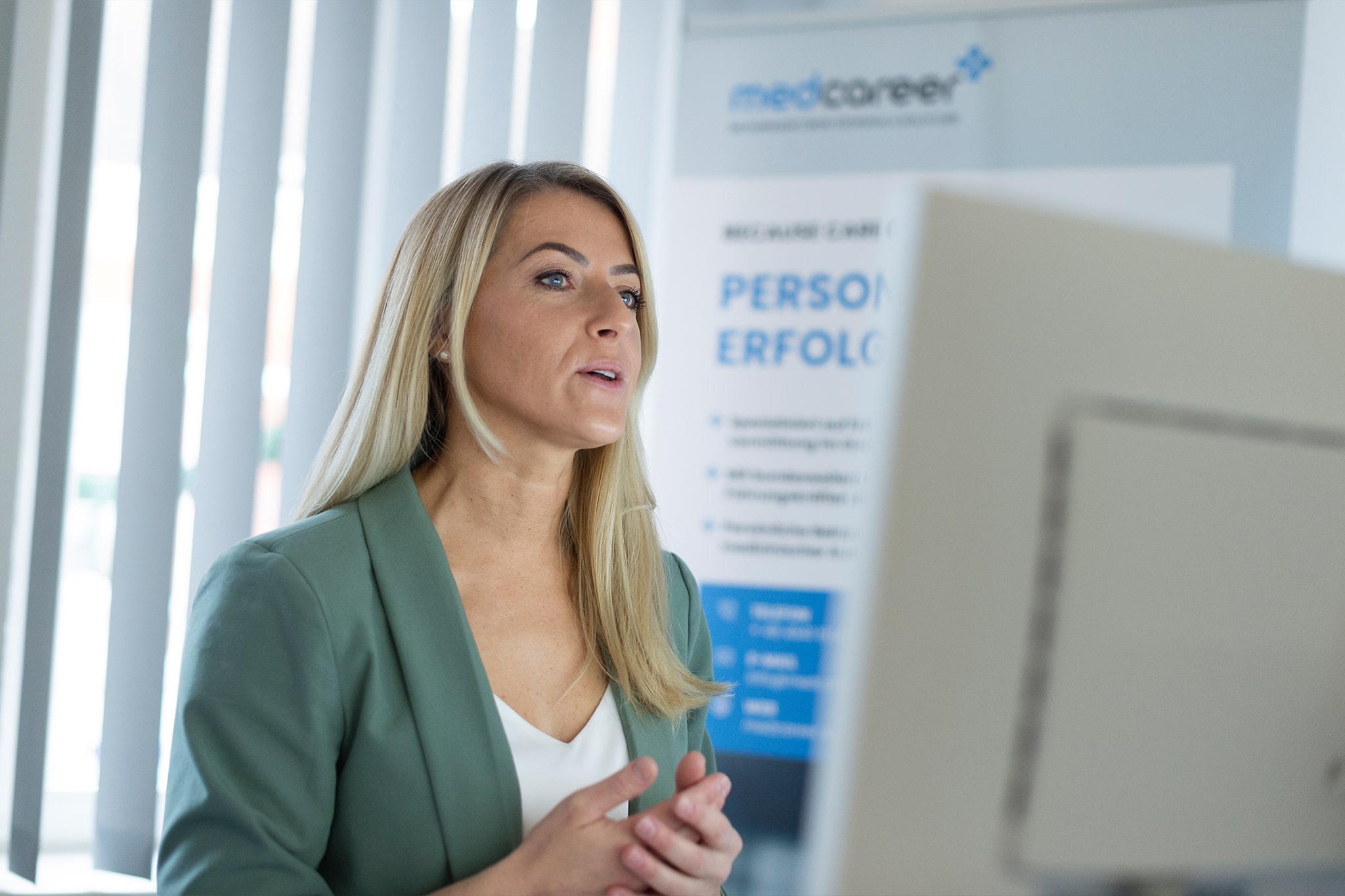 Frau im Business-Outfit vor medcareer Banner