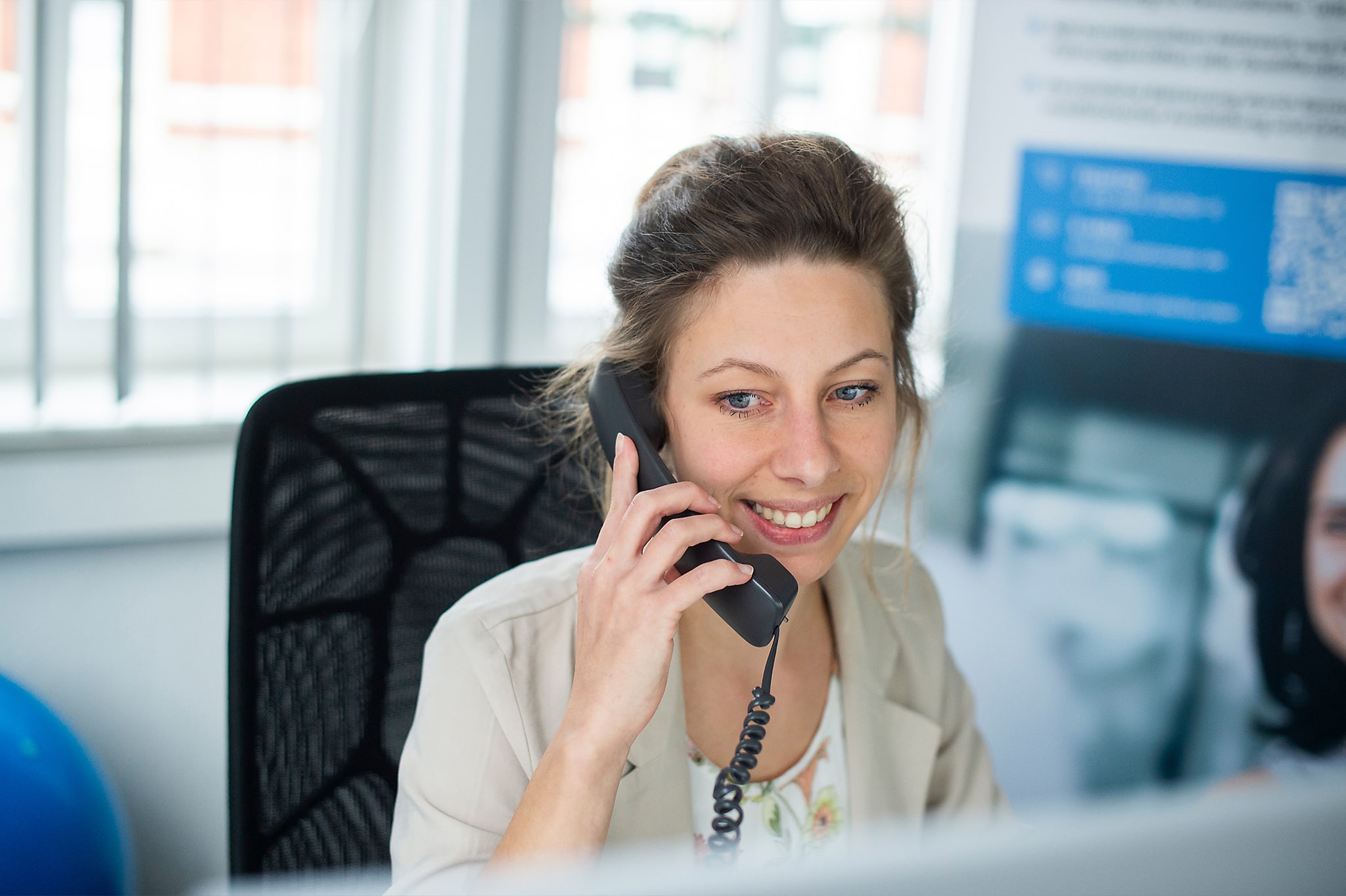 Mitarbeiterin im Büro mit Headset, symbolisiert Kundenservice bei medcareer