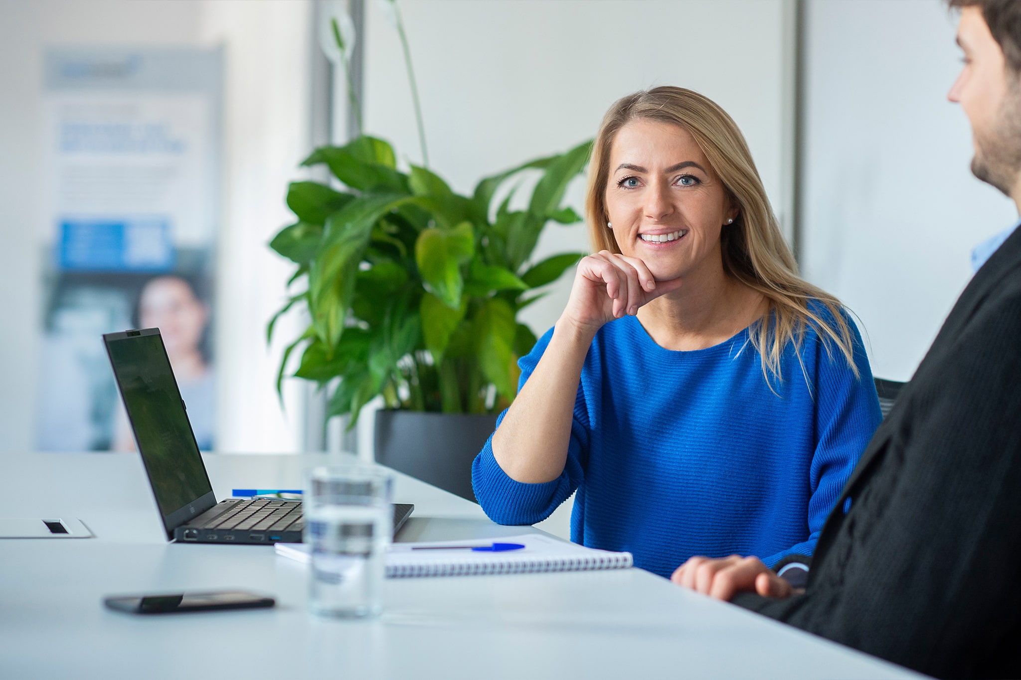 Frau mit blauem Pullover im modernen Büro bei medcareer