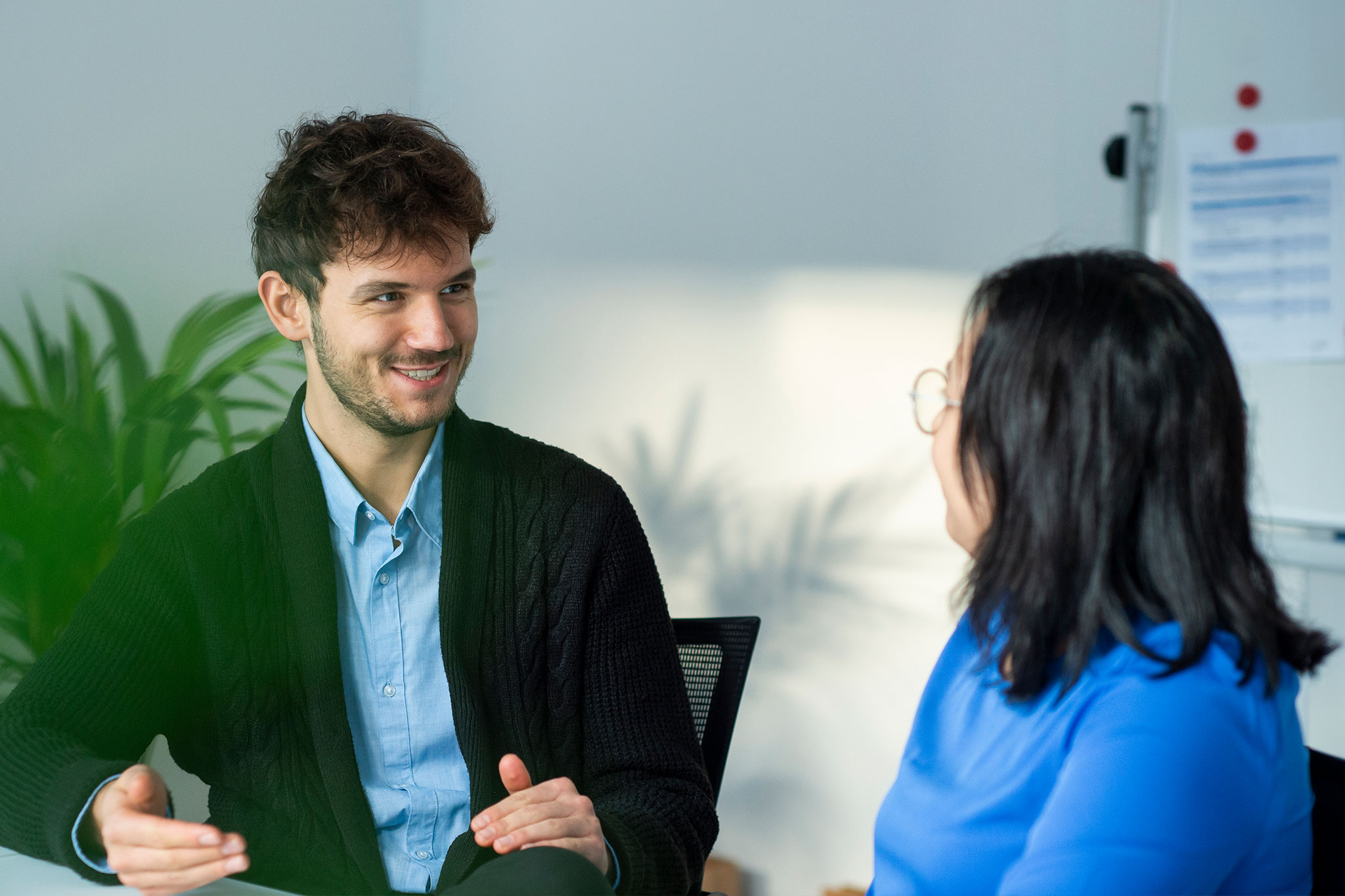 Mann und Frau im Gespräch im Büro, symbolisiert Beratung und Teamarbeit bei medcareer
